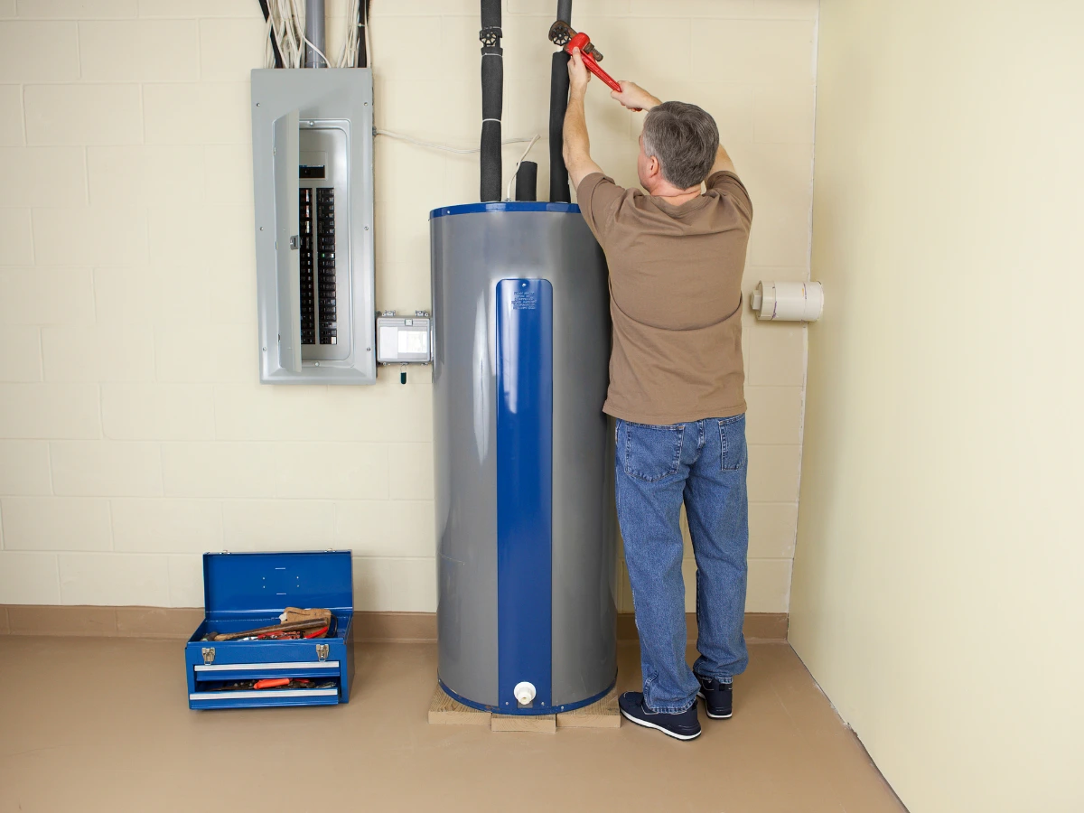 A professional plumber repairing a water heater that’s making whistling sounds.
