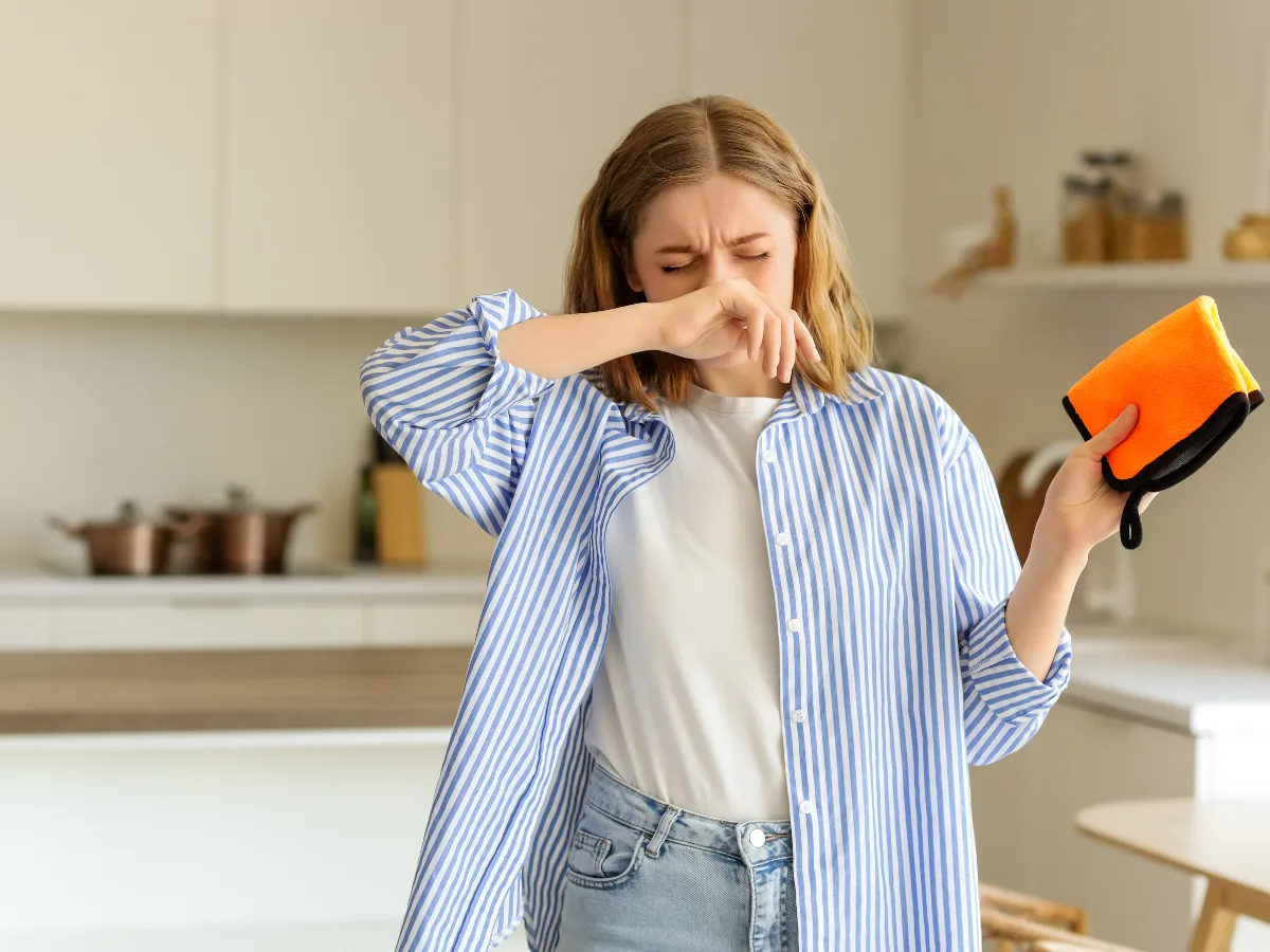 A woman having an allergic reaction due to unhealthy air caused by clogged drains.