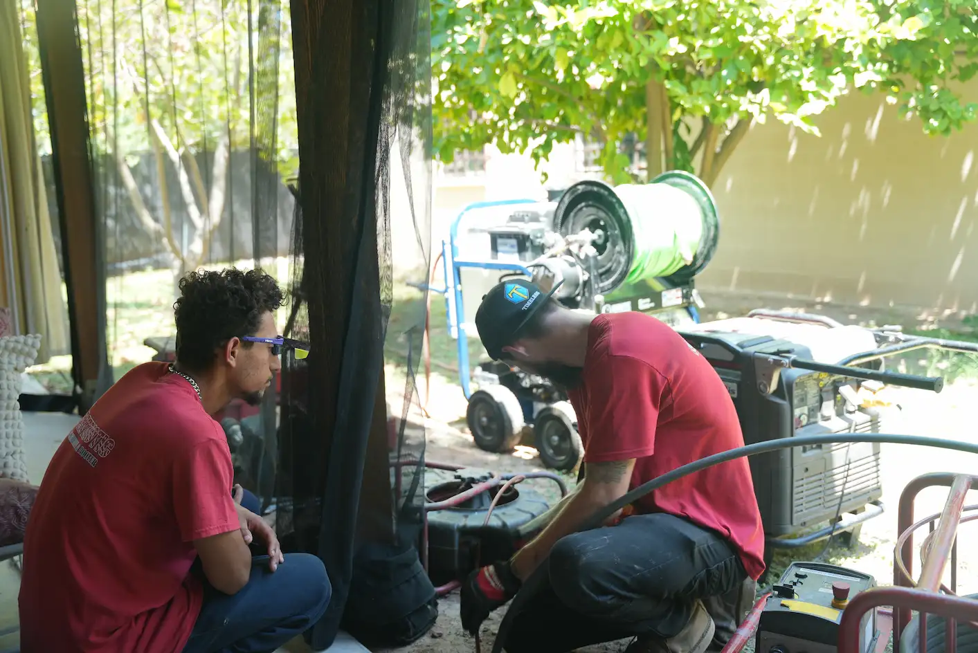 Two Patriotic plumbers conduct a trenchless sewer line repair in a residential home