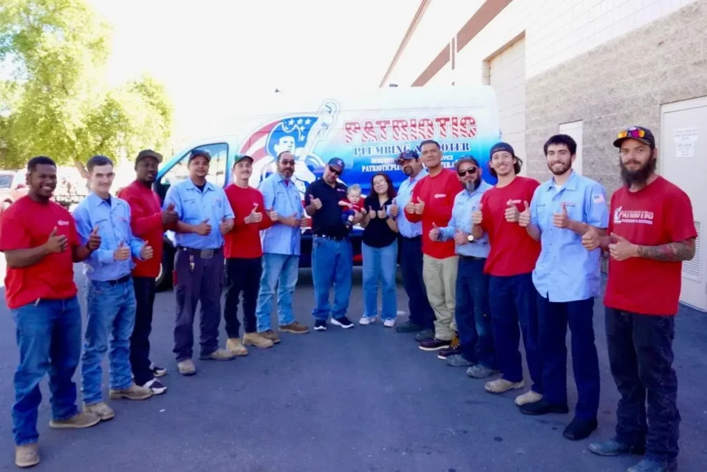 The Patriotic Rooting and Plumbing team poses with their thumbs up.